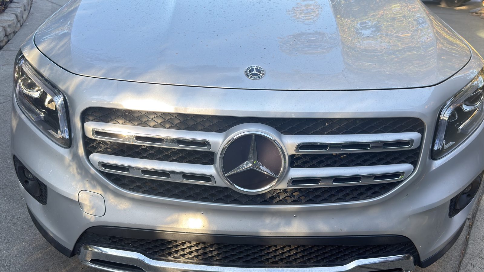 Silver Mercedes-Benz GLB 250 before an ICON detail — the front grille and bumper dulled by road film