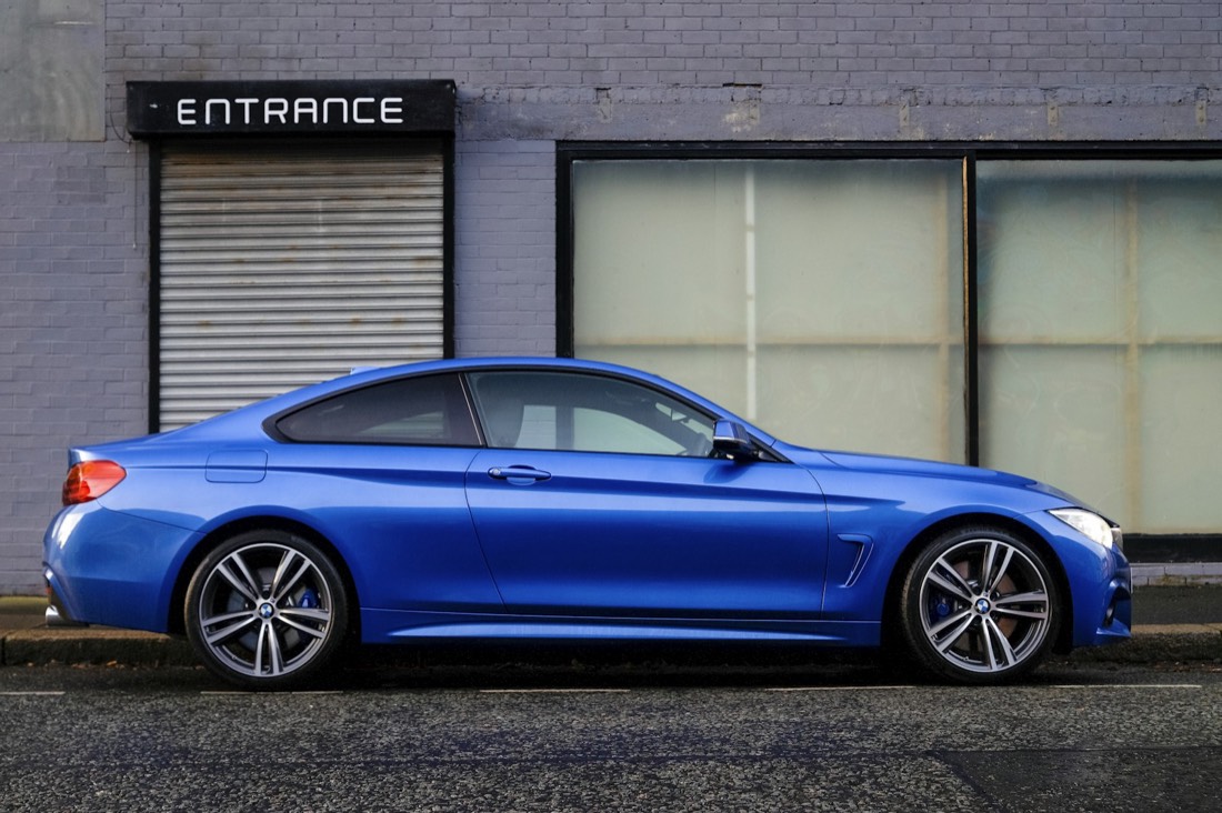 Blue sports coupe in profile showing a flawless side panel and dressed wheels